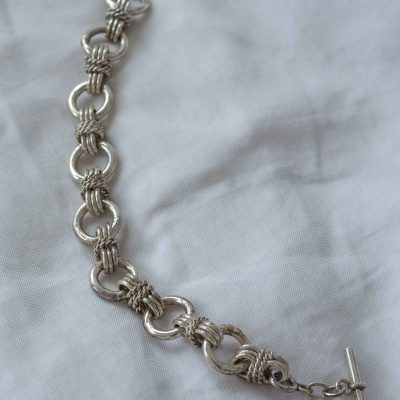 Pulsera triple de eslabones circulares, en ocho y trenzados con cierre en T